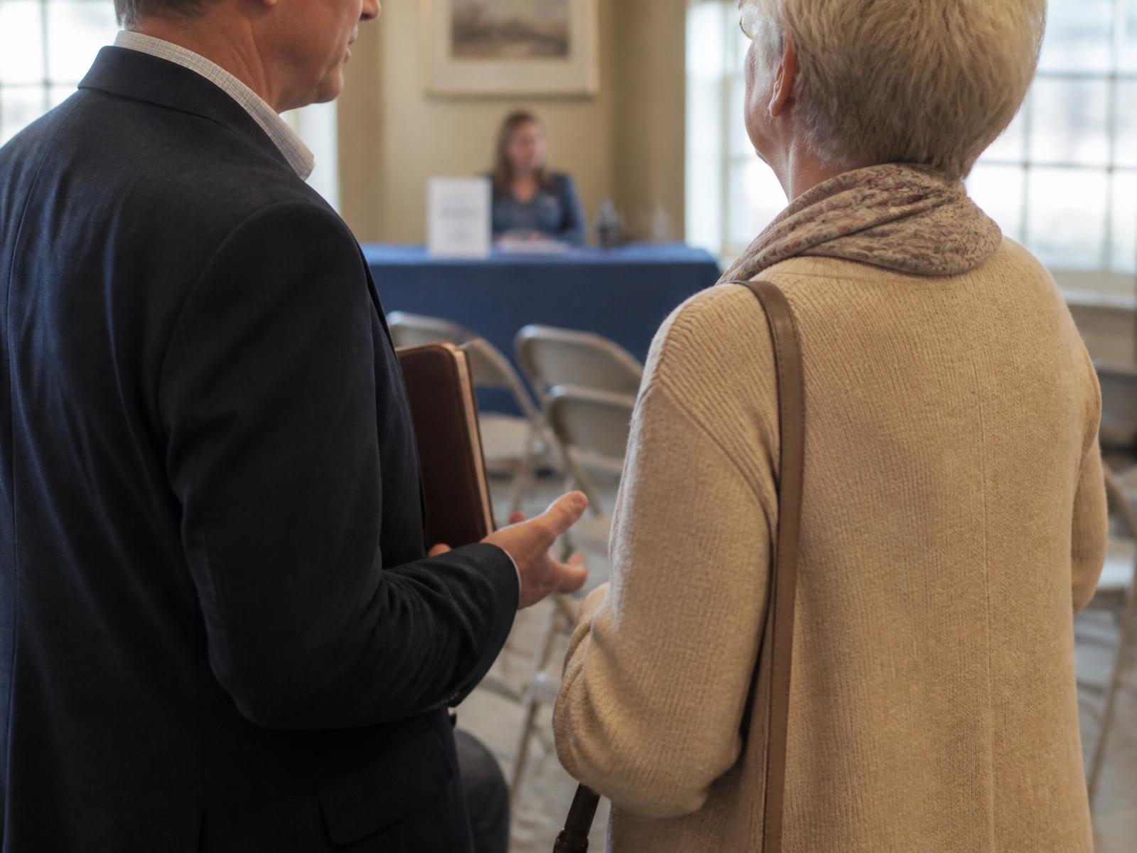 An advisor speaking with an attendee after an educational seminar
